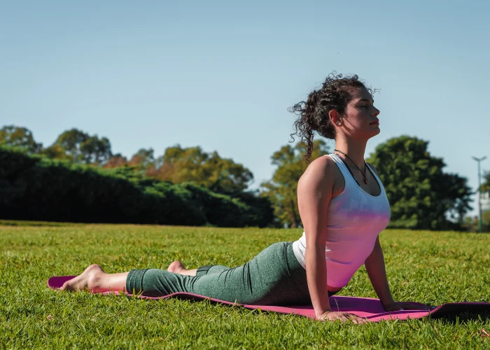 Young woman practicing upward-facing cobra yoga pose