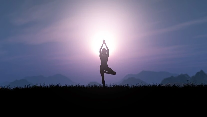 Silhouette of a yoga pose against a colorful sunset